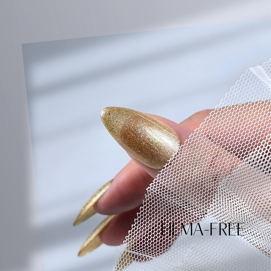 A close-up of a thumb painted with White Diamond Nails gel polish in Golden Love, shade 328, featuring a rich golden shimmer for a luminous and eye-catching finish, set against a clean, modern background.