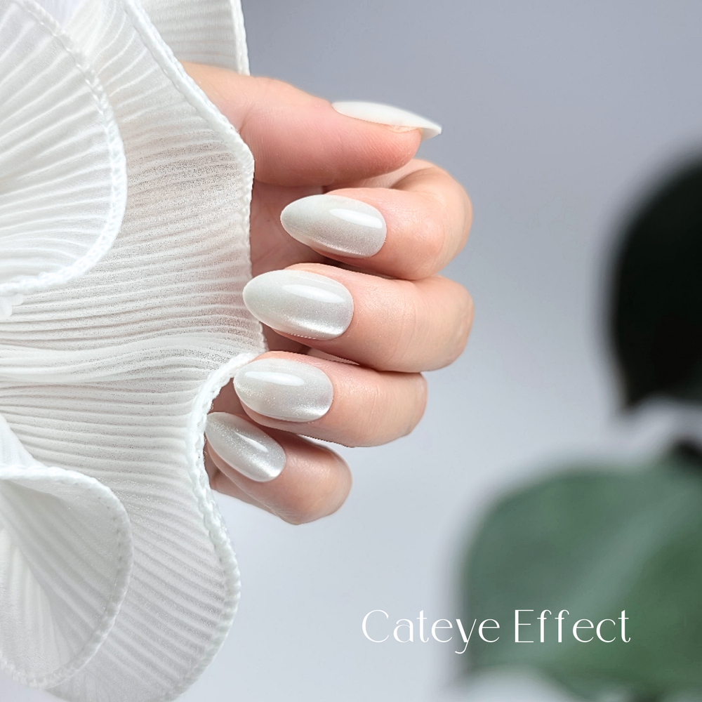 Hand with silver shimmer press-on nails, 119 Silver Sky reusable gel press-ons, almond shape nails, premium silver nails with soft background