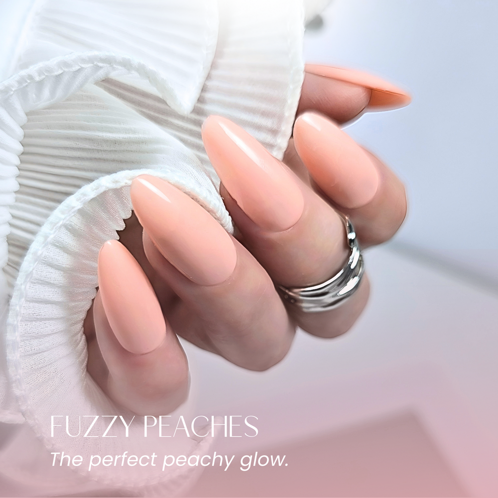 Elegant peach gel manicure holding pleated white fabric