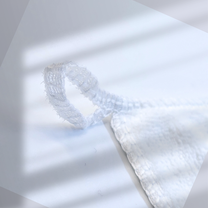 A close-up of the hook on the white microfiber manicure towel, with 'White Diamond Nails' knitted in silver, showcasing its convenient hanging design and luxurious branding, ideal for professional or home use.