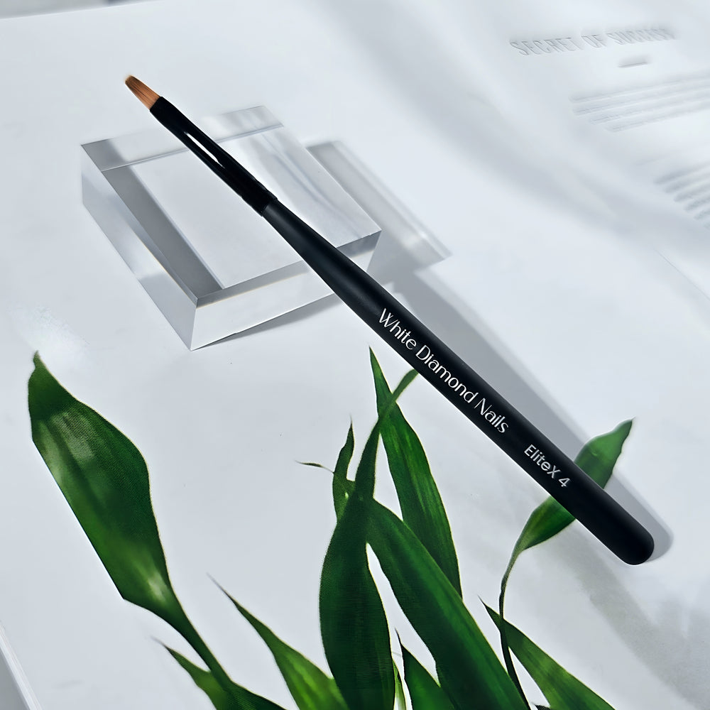 EliteX 4 Oval Gel Brush by White Diamond Nails displayed on white background with green leaves – pro gel brush for precise application