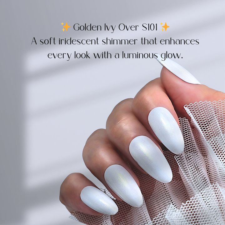 A hand with almond-shaped white nails, coated with White Diamond Nails SHIMMER TOP 02 – Golden Ivy over Gel Polish S101, creating a delicate iridescent shimmer. The sheer golden glow subtly catches the light, adding a touch of luxury. The fingers elegantly hold soft white mesh fabric.